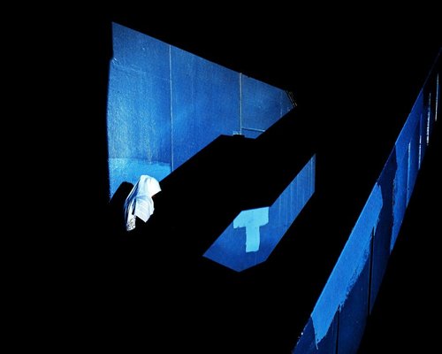 Abstract composition of blue lights and dark shadows in an urban night setting